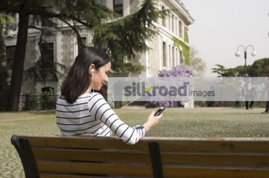 Student sitting on the bench using a mobile|