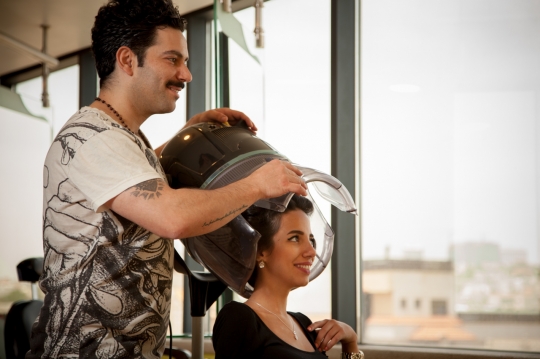 Hair stylist putting the blow dry machine over the woman's head|