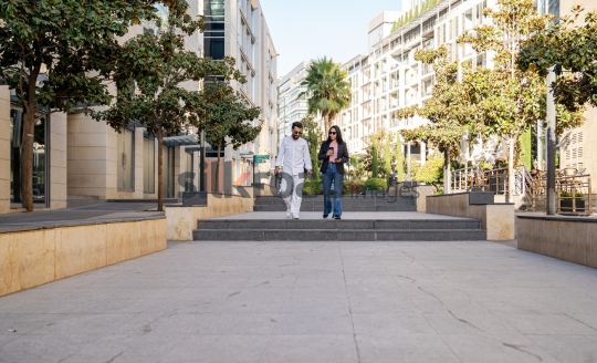 Professional Man and Woman Smiling with Coffee in Al Abdali Boulevard