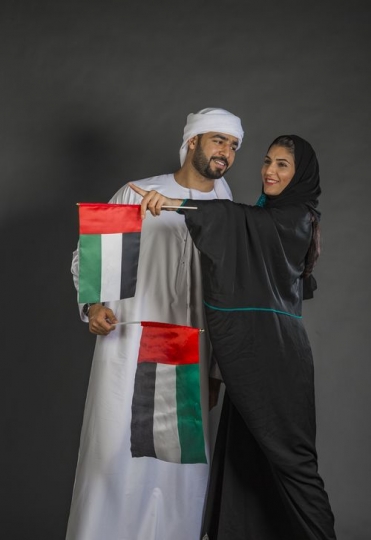 Middle Eastern man and woman celebrating the UAE National day