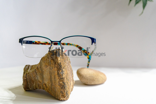 Stylish Eyeglasses on Stone with White Background